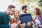 Image of four happy smiling young friends walking outdoors in the park