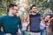 Image of four happy smiling young friends walking outdoors in the park