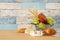 image of fruits in the tin basket over wooden table.