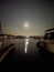 Image of the full moon reflecting in the ocean harbour