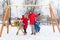 Image of girl and boy swinging in winter in park with parents