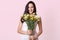 Image of girl holding bouquet of flowers in the hands, chorming lady expresses happyness, looking directly at camera, being in