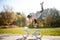 Image of girl in skirt with raised leg riding bike in autumn park