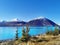An image of glacier waters of Lake Ohau in the South Island of New Zealand with mountains and blue sky