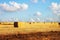 Image of gold wheat haystacks field and blue sky.