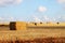 Image of gold wheat haystacks field and blue sky.