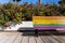 Image of half Rainbow colored bench with floral background in the city in Valencia, Spain