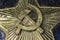 Image of a hammer and sickle on a pentagonal star of the USSR period. Metal bas-relief on marble close-up. Berel Dismantled in