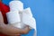 Image of a hand holding several rolls of toilet paper