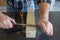 Image of the hands of a carpenter craftsman who smoothes a piece of wood with a rasp. Wood filing and cleaning