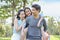 Image of happy asian family, daughter riding behind father while parents smiling during summer time in the park