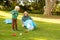 Image of happy caucasian grandmother and grandson with rubbish bags in garden