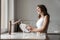 Image of happy caucasian woman smiling and washing dishes