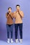 Image of happy friends loving couple standing isolated over purple background screaming looking camera
