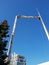 Image of high mobile crane with manipulator and bucket for workers against blue sky and bright sun