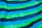 Image with horizontal stripes of the colors black, green, blue, on waste paper