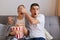 Image of impressed man watching horror film with woman, shocked husband covered his wife`s eyes with palm, forbidden content on t