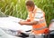 Image of insurance company officers post a list of repairs on work list clipboard with sun flare and accident cars