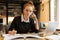 Image of intelligent girl studying, while sitting at desk in col