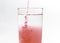 An image isolated pouring beverage or red water drink fresh or sirup cranberry mixed water in the glass clean on white background