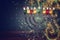 image of jewish holiday Hanukkah background with crystal menorah & x28;traditional candelabra& x29; and colorful oil candles