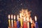 Image of jewish holiday Hanukkah background with menorah (traditional candelabra) Burning candles over black background