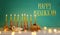 Image of jewish holiday Hanukkah with creative menorah traditional Candelabra, donut and wooden dreidel spinning top