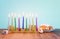 Image of jewish holiday Hanukkah with menorah traditional Candelabra, donut and wooden dreidel spinning top