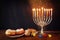 image of jewish holiday Hanukkah with menorah (traditional Candelabra), donuts and wooden dreidels (spinning top)