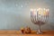 Image of jewish holiday Hanukkah with menorah (traditional Candelabra) and wooden dreidels (spinning top).