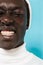 Image of joyous african american guy in white clothes smiling at camera