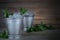 Image for Kentucky Derby in May showing two silver mint julep cups with crushed ice and fresh mint in a rustic setting.
