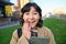 Image of korean girl with happy face, walks around town with student tablet, stands on street and smiles