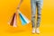 An image of legs, a woman after shopping stands with a lot of multi-colored bags, on a yellow background