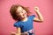 Image of little dancing girl wears beautiful dress on isolated pink background.