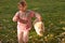 Image of little girl running happily on green meadow with small white puppy following behind