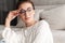 Image of lovely young woman in eyeglasses resting on sofa at home