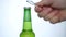 Image with Man`s Hand Trying to Open a Bottle of Beer Cold and Fresh using an opener