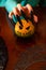 Image of man`s hands with pumpkin jack sitting at wooden table