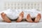 Image of man and woman bare feet under blanket in bedroom. Unrecognizable husband and wife spend free time in comfortable bed, enj