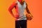Image of midsection of biracial basketball player with basketball on orange to yellow background
