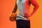 Image of midsection of biracial basketball player with basketball on orange to yellow background