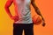 Image of midsection of biracial basketball player with basketball on orange to yellow background