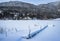 Image of a mountain lake in the winter covered in snow.