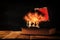 Image of mysterious treasure chest with flames over old book on wooden table.