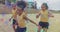 Image of networks over happy diverse schoolgirls playing football in sports field