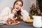 Image of nice caucasian woman eating strawberry while having breakfast