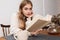 Image of nice caucasian woman reading book and drinking tea