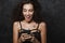 Image of nice delighted woman smiling and using cellphone