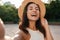 Image of nice middle-aged woman hat taking selfie photo and laughing while walking in summer park